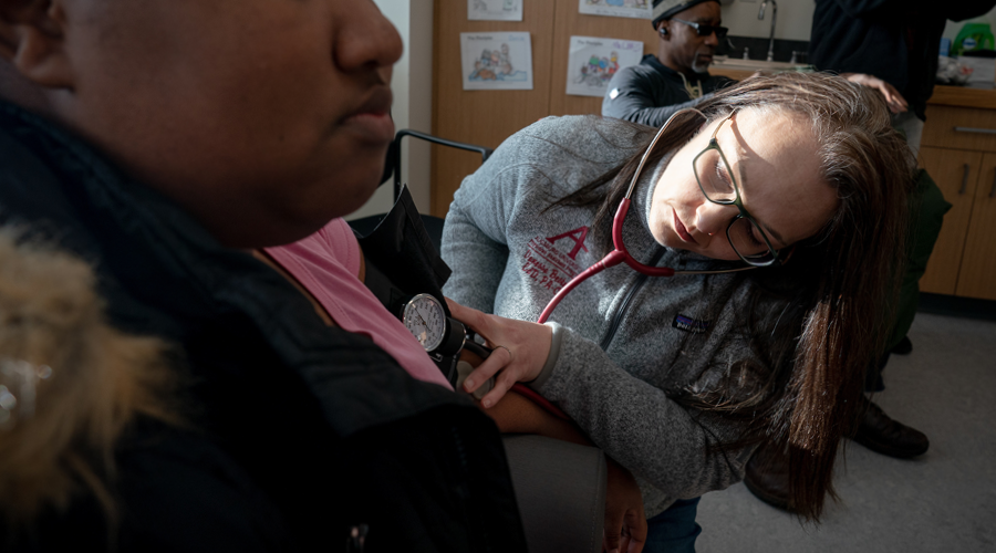 Physician’s Assistant Program Director Vanessa Bester takes a visitor's blood pressure at Augsburg Health Commons.